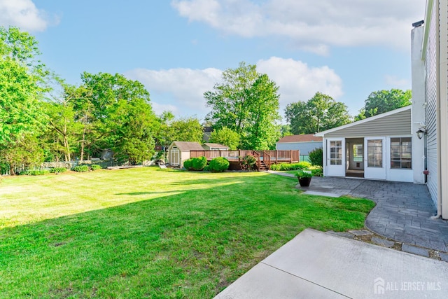 1682 Taylor Dr, North Brunswick, NJ 08902 - view of grassy yard with a patio area, a storage shed, and a wooden deck