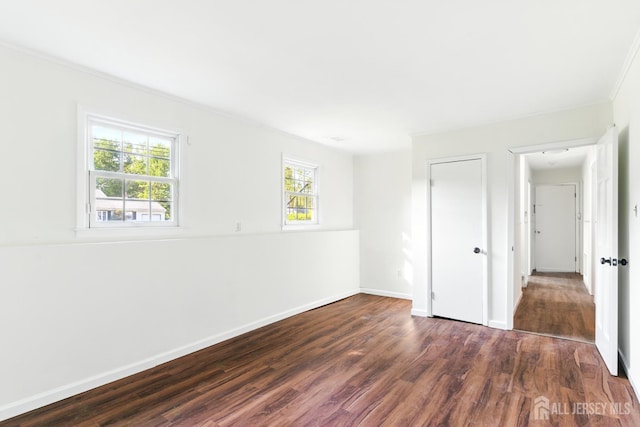 1682 Taylor Dr, North Brunswick, NJ 08902 - unfurnished bedroom with dark wood-type flooring, crown molding, and a closet