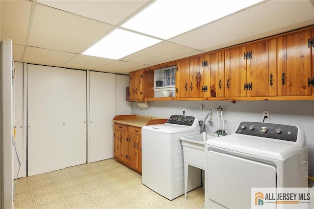 clothes washing area featuring cabinet space, washer and clothes dryer, and light flooring