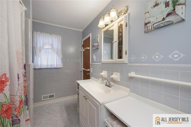 full bath with ornamental molding, vanity, a shower with curtain, a wainscoted wall, and tile walls