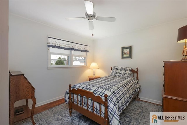 bedroom with baseboards, wood finished floors, crown molding, and a ceiling fan