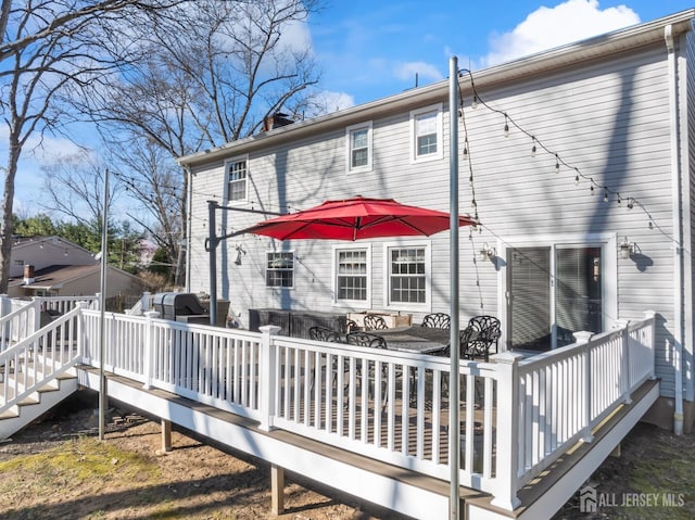 rear view of house featuring a wooden deck and a chimney