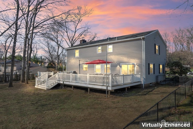rear view of house with a lawn, a fenced backyard, a chimney, and a deck