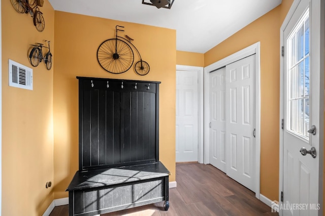 interior space featuring visible vents, baseboards, and wood finished floors