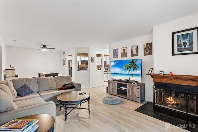 907 Meadow Ct, Helmetta, NJ 08828 - living area featuring a fireplace with flush hearth, light wood finished floors, and ceiling fan