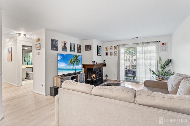 907 Meadow Ct, Helmetta, NJ 08828 - living room featuring light wood-style flooring and a warm lit fireplace