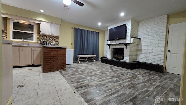 22 Delaney Ct, South Plainfield, NJ 07080 - kitchen featuring a ceiling fan, a sink, a brick fireplace, light wood finished floors, and recessed lighting