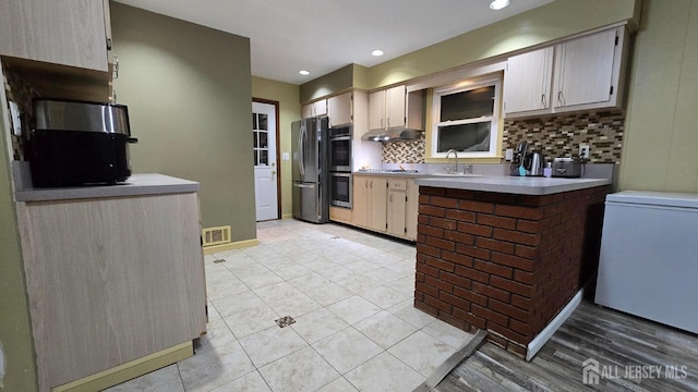 22 Delaney Ct, South Plainfield, NJ 07080 - kitchen featuring stainless steel appliances, backsplash, a sink, light countertops, and a peninsula