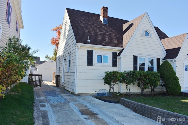 30 John St, South River, NJ 08882 - back of property with an outdoor structure, roof with shingles, a garage, and a chimney