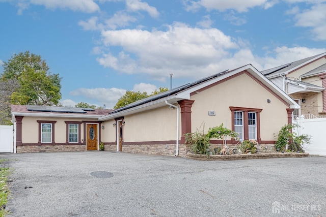 single story home featuring solar panels