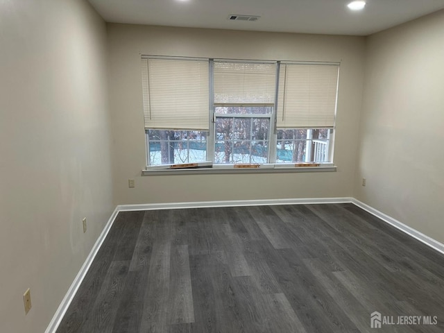 empty room with plenty of natural light and dark wood-type flooring