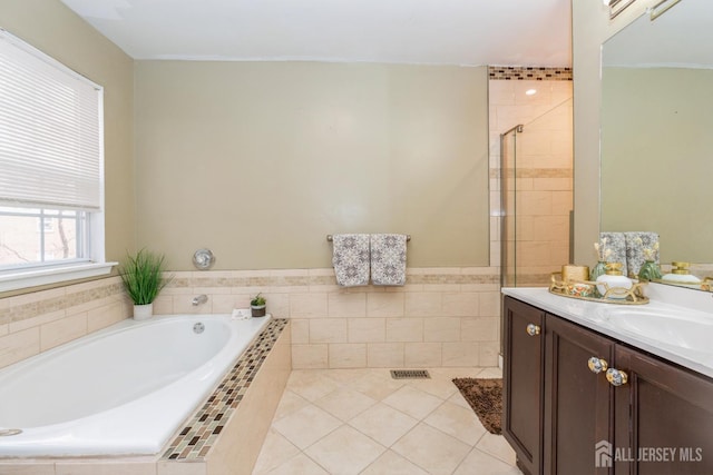 bathroom with visible vents, a garden tub, a stall shower, tile patterned flooring, and vanity