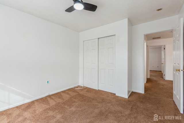 unfurnished bedroom featuring a closet, carpet flooring, baseboards, and visible vents