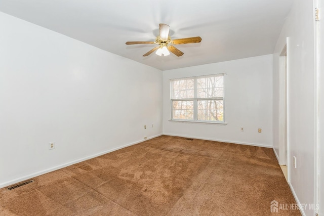 unfurnished room with carpet flooring, a ceiling fan, visible vents, and baseboards