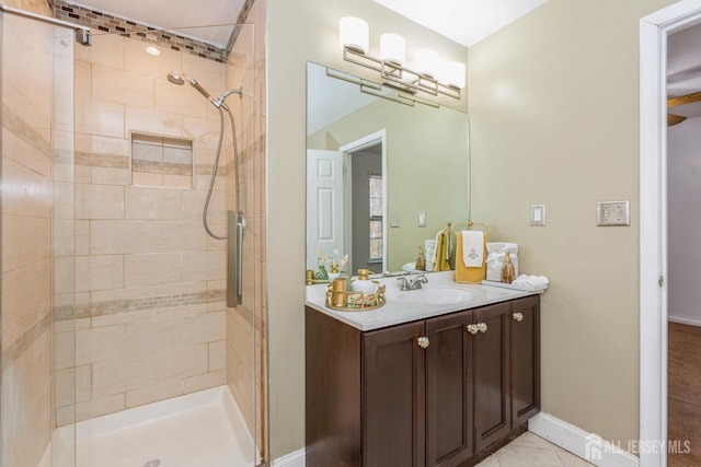 full bath featuring vanity, a shower stall, and baseboards