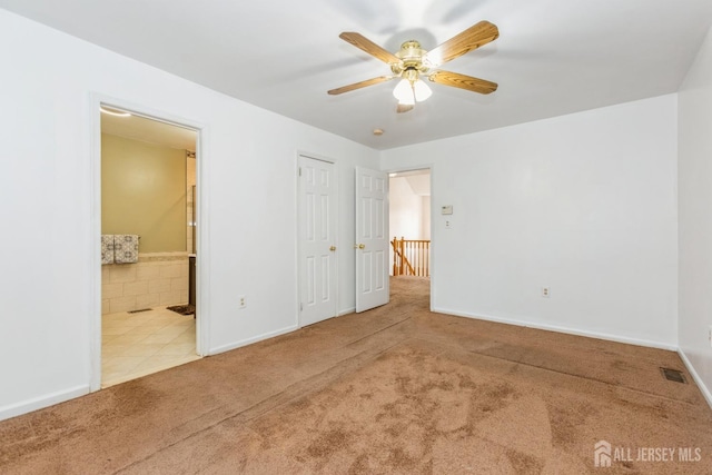 unfurnished bedroom with baseboards, carpet floors, and connected bathroom