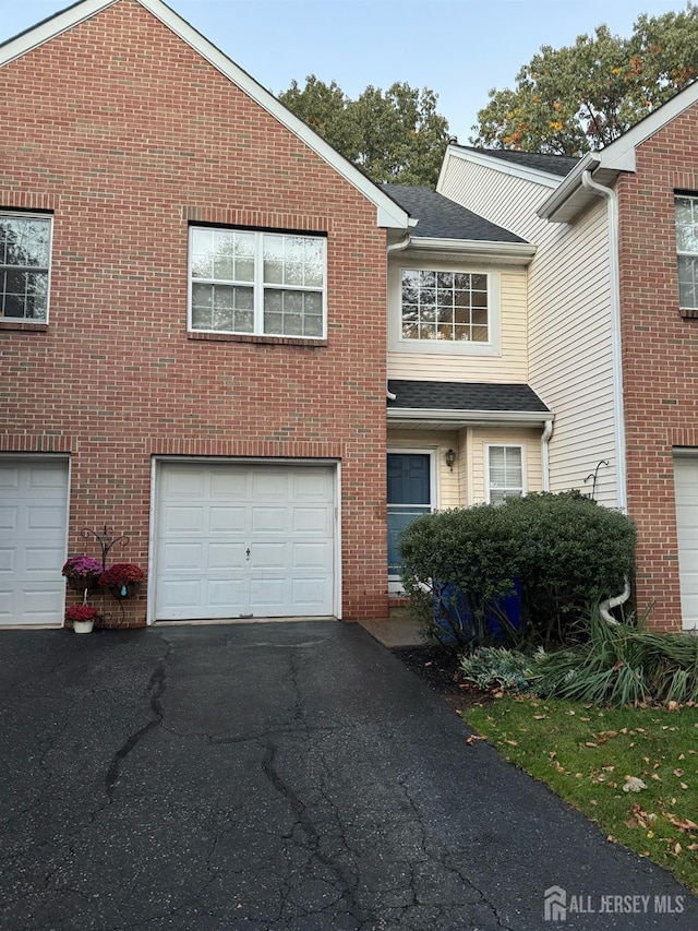 view of front of house featuring a garage, brick siding, and driveway