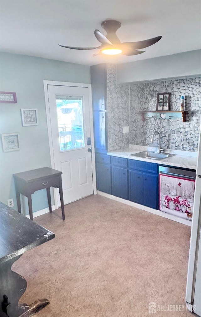 kitchen with blue cabinets, tasteful backsplash, a ceiling fan, and a sink