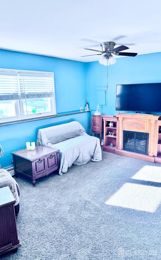 bedroom featuring carpet floors, ceiling fan, and a fireplace