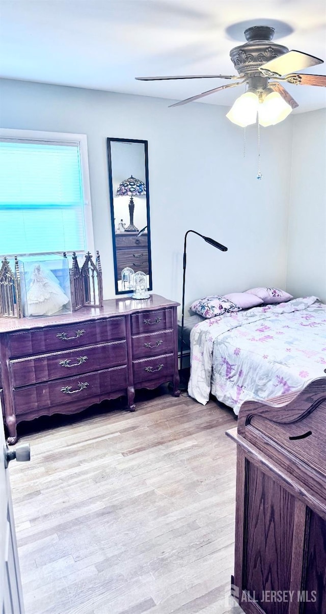 bedroom with ceiling fan and light wood-style flooring