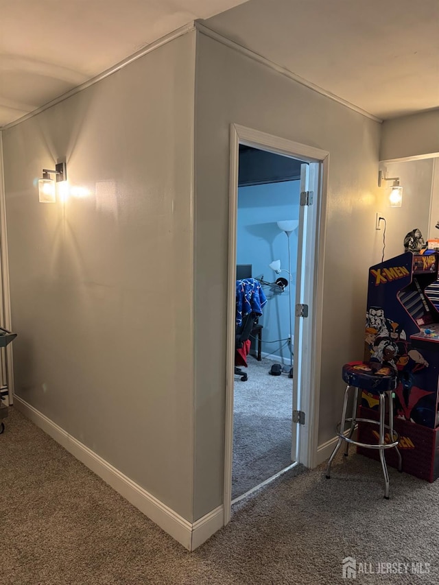 corridor with baseboards and carpet flooring