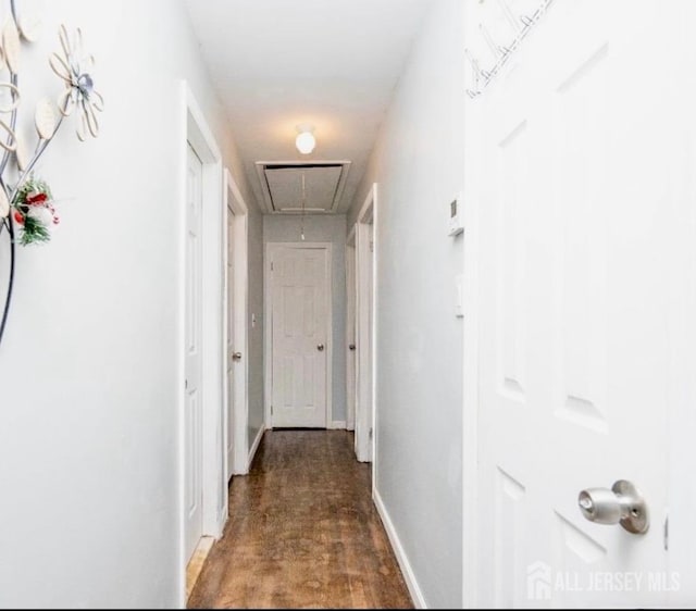 hallway featuring attic access and baseboards