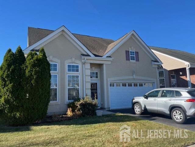 view of front of property featuring a front yard and a garage