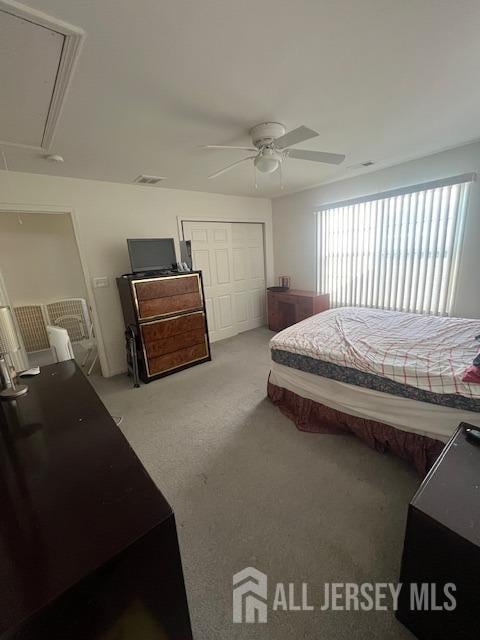 carpeted bedroom featuring a closet and ceiling fan