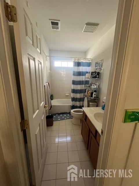 full bathroom featuring tile patterned flooring, shower / bath combo, vanity, and toilet