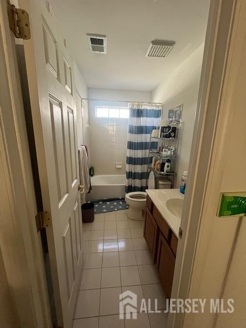 full bathroom featuring toilet, vanity, tile patterned flooring, and visible vents