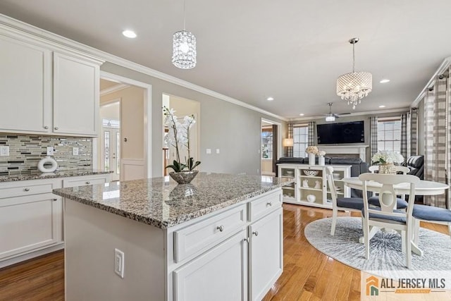 20 Washingtons Xing, Monroe, NJ 08831 - kitchen with a fireplace, light wood-style floors, ornamental molding, decorative backsplash, and white cabinets