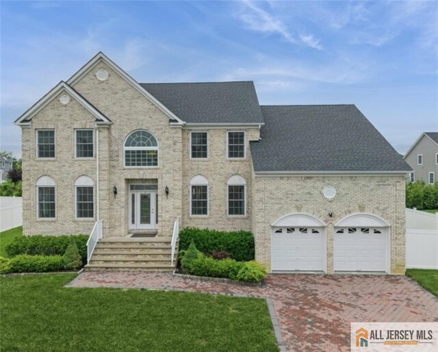 20 Washingtons Xing, Monroe, NJ 08831 - view of front facade featuring driveway, a shingled roof, brick siding, and an attached garage