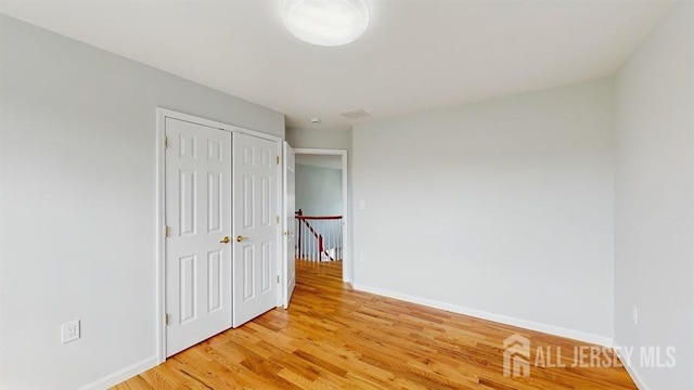 46 Carriage Dr, Piscataway, NJ 08854 - unfurnished bedroom featuring light wood finished floors, baseboards, and a closet