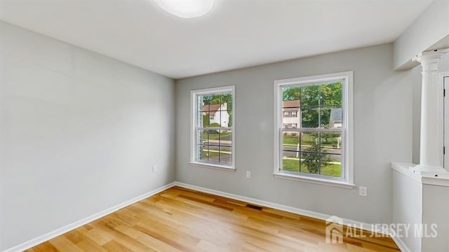 46 Carriage Dr, Piscataway, NJ 08854 - empty room with light wood-style floors, baseboards, and decorative columns