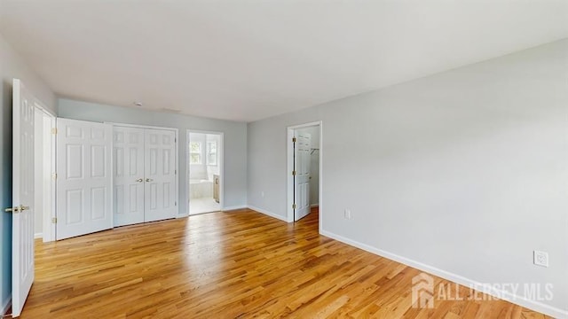 46 Carriage Dr, Piscataway, NJ 08854 - unfurnished bedroom with light wood-style flooring, baseboards, a closet, and connected bathroom