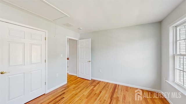 46 Carriage Dr, Piscataway, NJ 08854 - unfurnished bedroom with attic access, multiple windows, light wood-type flooring, and baseboards