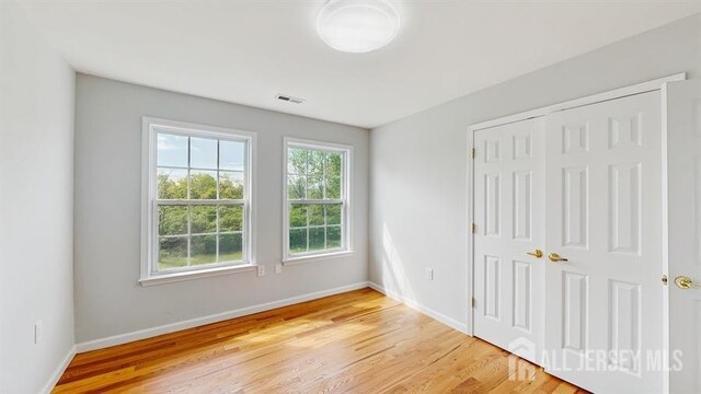 46 Carriage Dr, Piscataway, NJ 08854 - unfurnished bedroom featuring light wood-style floors, baseboards, and a closet