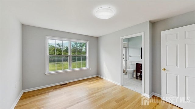 46 Carriage Dr, Piscataway, NJ 08854 - unfurnished bedroom with light wood-style floors, baseboards, and ensuite bath