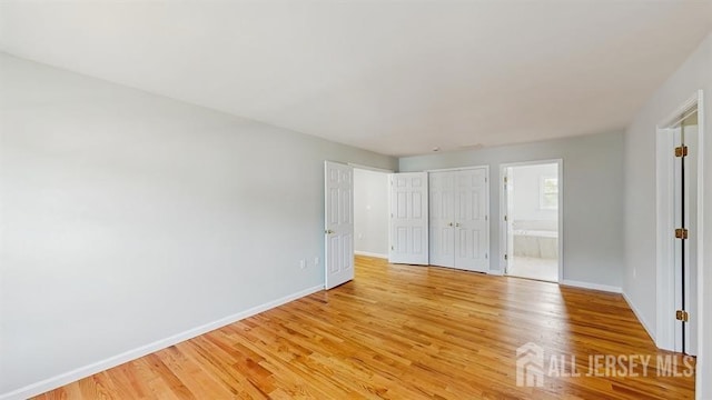 46 Carriage Dr, Piscataway, NJ 08854 - unfurnished bedroom featuring light wood finished floors, baseboards, ensuite bath, and a closet