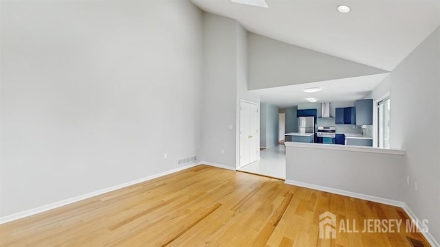 46 Carriage Dr, Piscataway, NJ 08854 - unfurnished living room featuring high vaulted ceiling, light wood-style floors, baseboards, and a sink