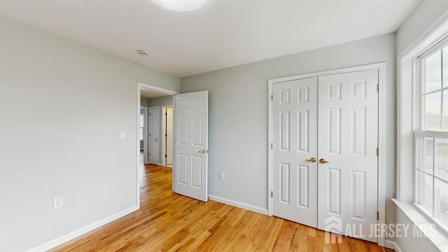 46 Carriage Dr, Piscataway, NJ 08854 - unfurnished bedroom with light wood-style flooring, baseboards, and a closet