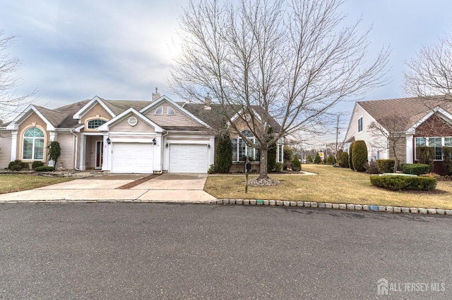 view of front of home featuring concrete driveway, a front lawn, a chimney, and an attached garage