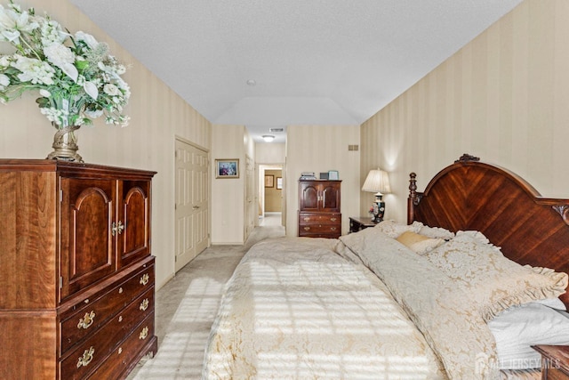 bedroom featuring lofted ceiling and light carpet