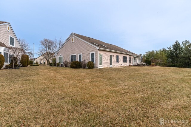 back of property featuring a lawn