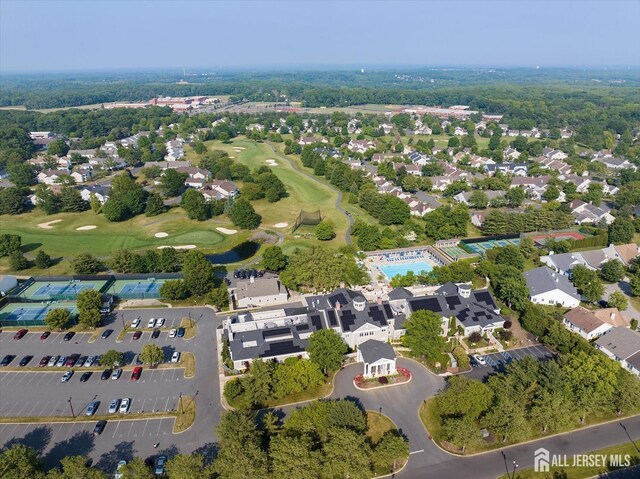 drone / aerial view featuring view of golf course and a residential view