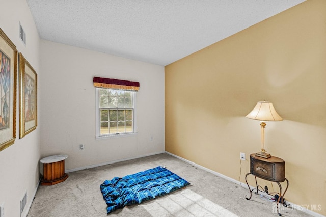 carpeted bedroom featuring baseboards, visible vents, and a textured ceiling