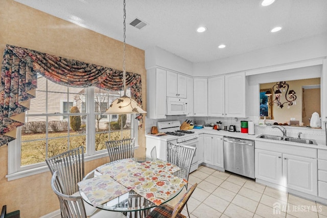 kitchen featuring white cabinetry, sink, light tile patterned floors, and white appliances