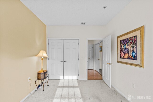 interior space featuring carpet flooring, visible vents, and baseboards