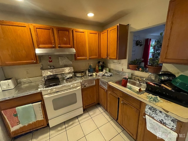 308 Seaman St, New Brunswick, NJ 08901 - kitchen with white gas range oven, under cabinet range hood, a sink, light tile patterned flooring, and brown cabinets