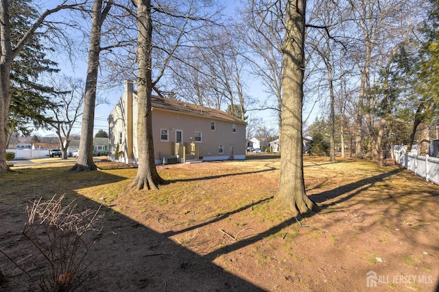 view of yard featuring cooling unit and fence